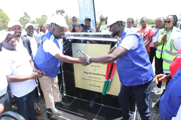 CS Eric Mugaa shakes hands with Tana Water Works Development Agency CEO Philip Gichuki after launching Phase 2 of the Tigithi-Humuka Water Project, with Laikipia Governor Joshua Irungu, MP Mwangi Kiunjuri, and other leaders looking on.